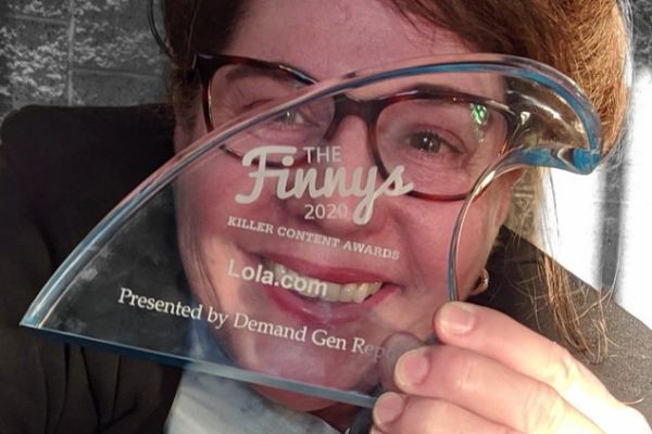 Jeanne Hopkins poses with Lola.com's Finny for best Audio Content!